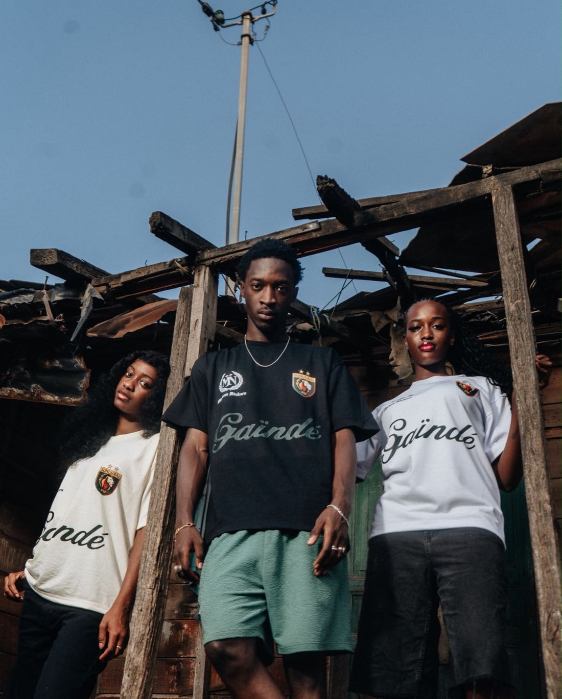 Trois modèles portant les maillots Gaïndé crème, noir et blanc dans un quartier de Dakar