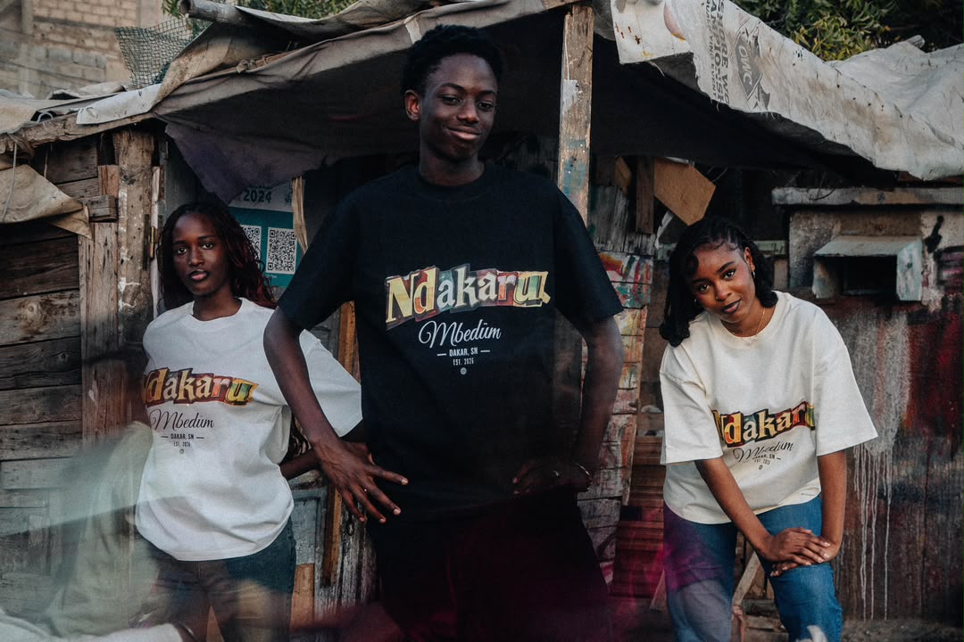 Trois modèles en t-shirts Ndakaru dans une rue de Dakar